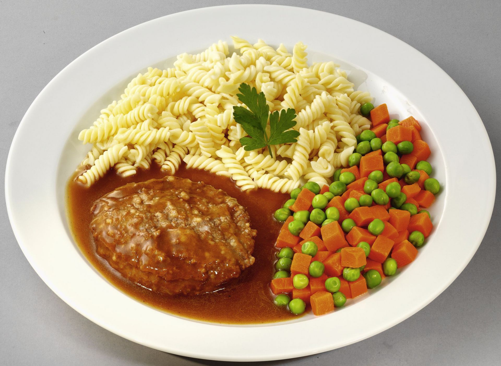 Deutsches Beefsteak mit Erbsen und Möhren, dazu Spiralnudeln | 13023